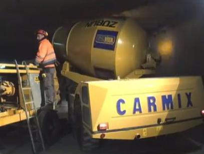 Carmix selbstladender Betonfahrmischer an Betonpumpe im Tunnel